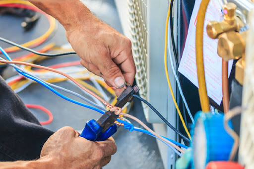 A professional air conditioning installer works to provide quality service for a homeowner in Calgary.